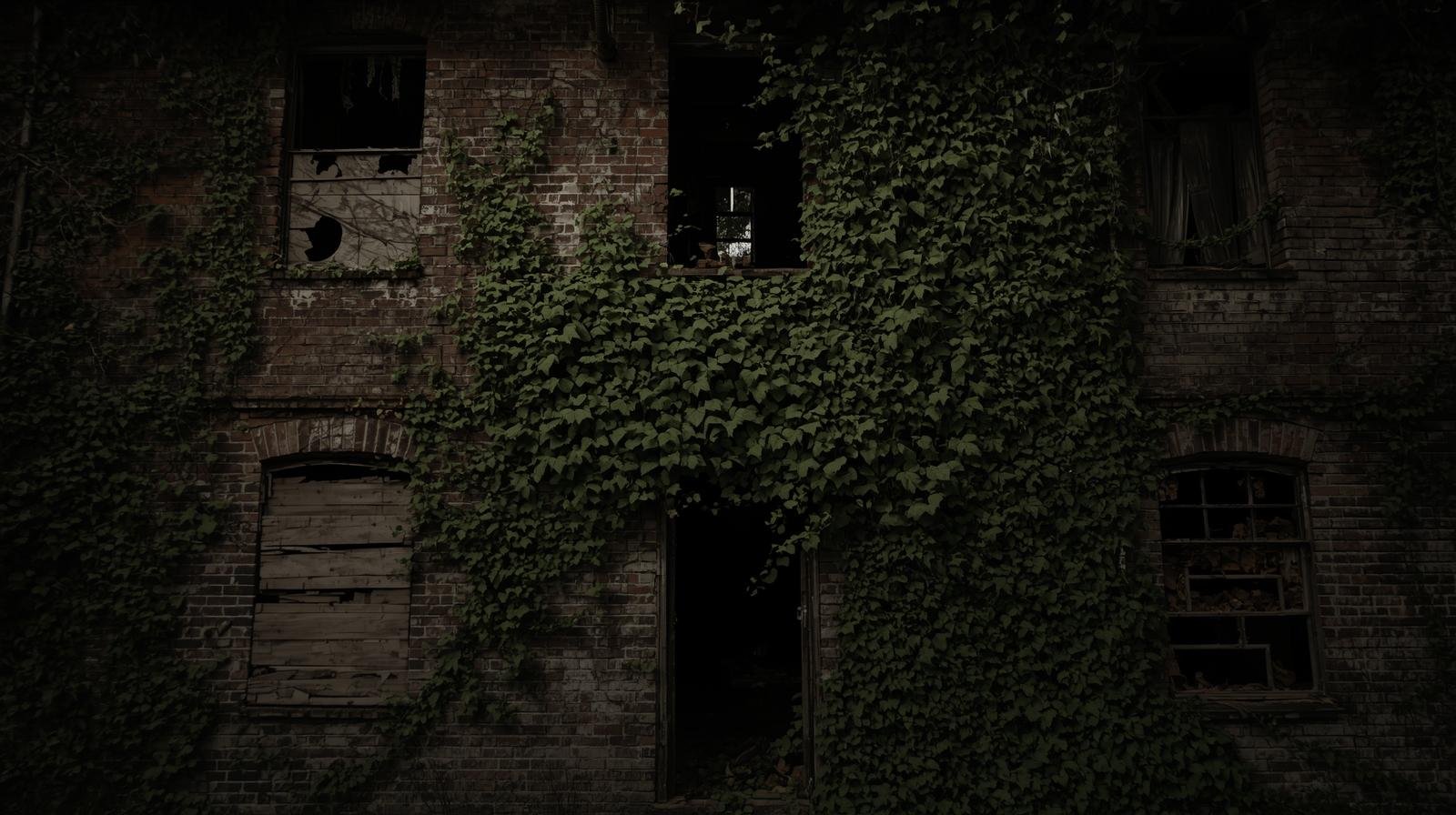 An abandoned brick house with cracked windows